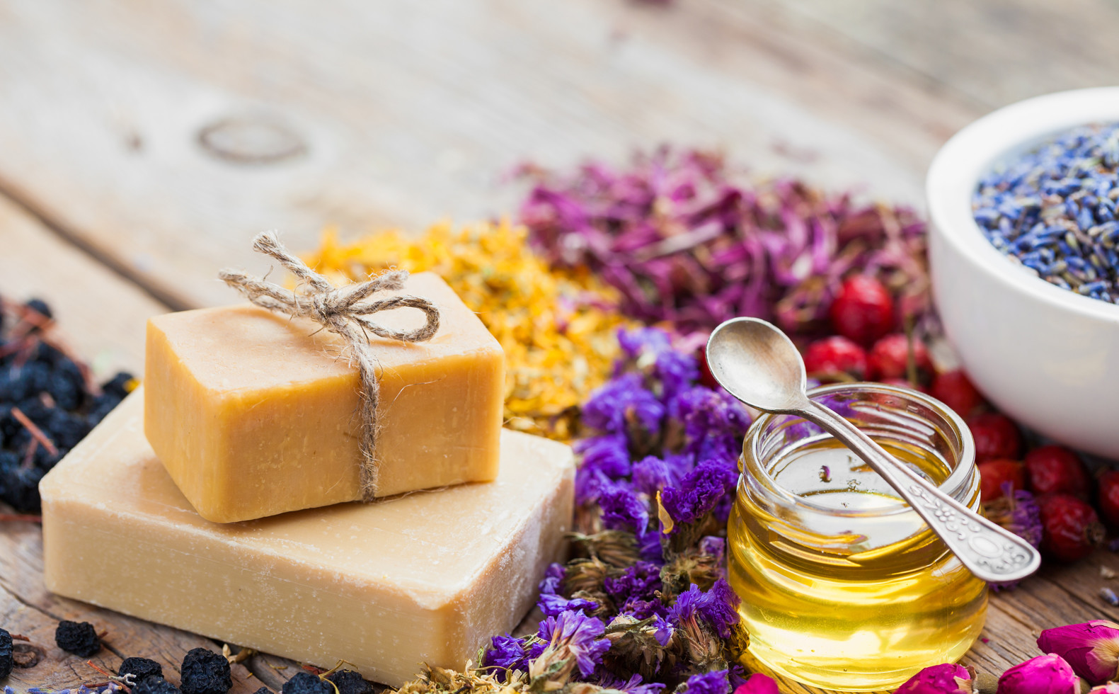 Bars of homemade soaps, honey or oil and healing herbs